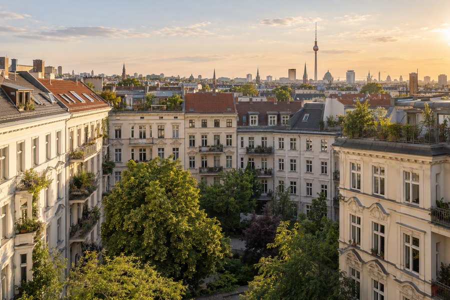 Illustrative Berliner Wohnbebauung mit begrüntem Innenhof und Blick über die Dächer